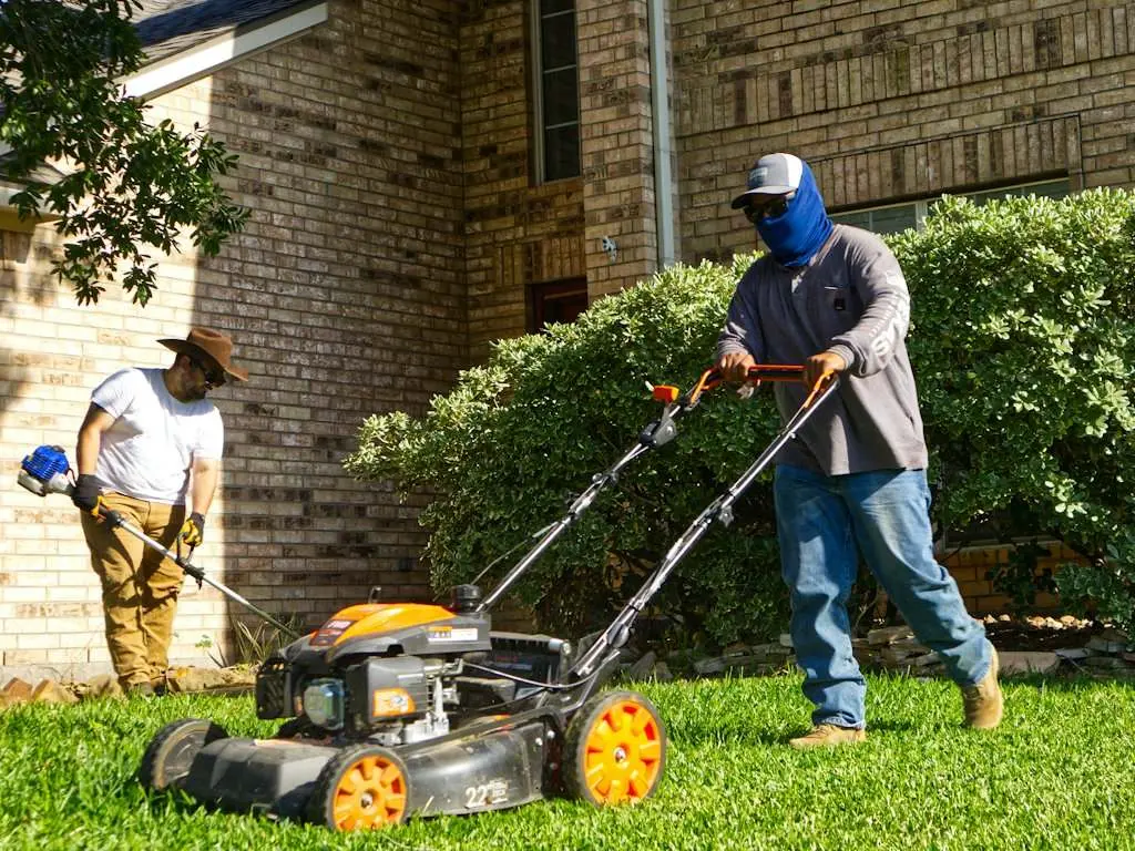 A landscape crew mowing and trimming at a commercial property