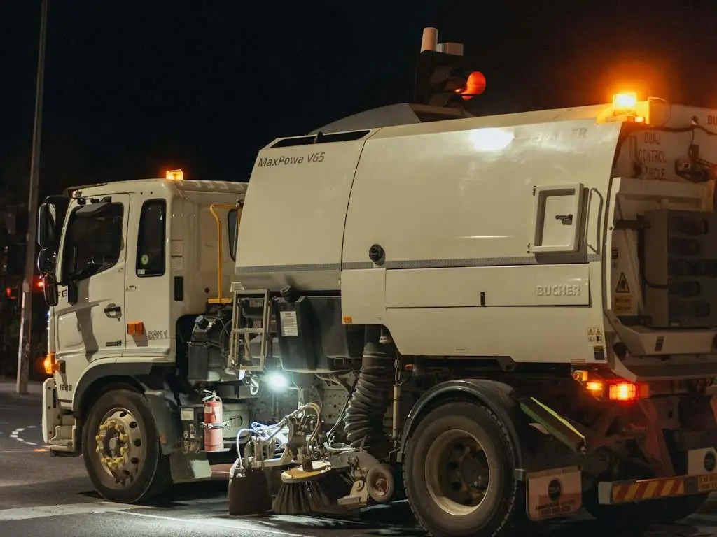 A street sweeper truck working at night
